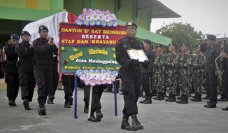 Police officers carry the coffin containing the body of their colleague who were killed in the latest attack by separatists near a giant gold and copper mine in Papua, during a funeral procession in Timika, Indonesia, Wednesday, Nov. 15, 2017. Tensions in the region have flared in the past month as members of the National Liberation Army of West Papua have declared an area near the mine a battlefield with Indonesian security forces. (AP Photo/Mujiono)
