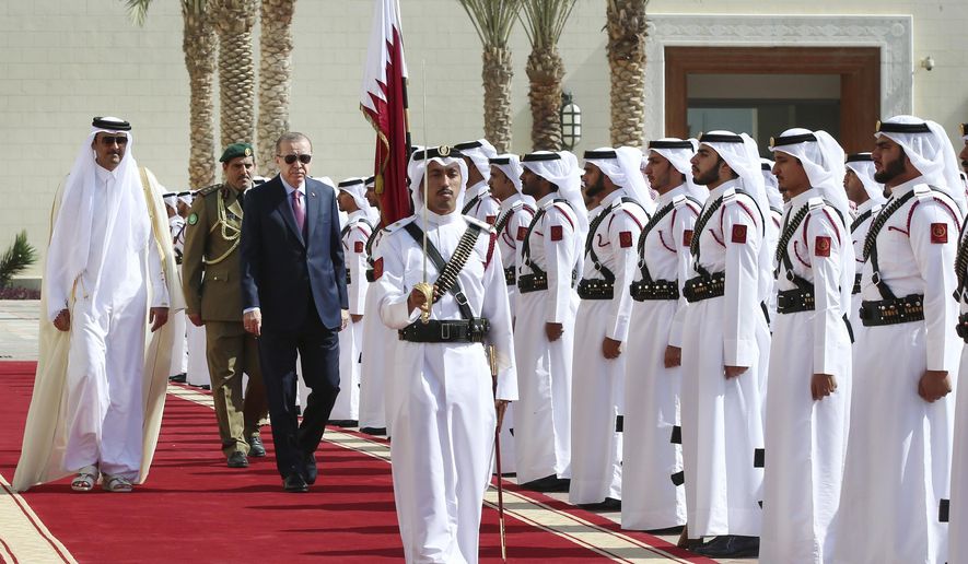 Turkey&#x27;s President Recep Tayyip Erdogan, left, centre, walks with the Emir of Qatar Sheikh Tamim bin Hamad Al Thani, left, as they review an honour guard during the welcome ceremony prior to the meeting in Doha, Qatar, Wednesday, Nov. 15, 2017. Erdogan is in a two day tour in the Middle East, that also took him to Kuwait. (Kayhan Ozer, Pool via AP)