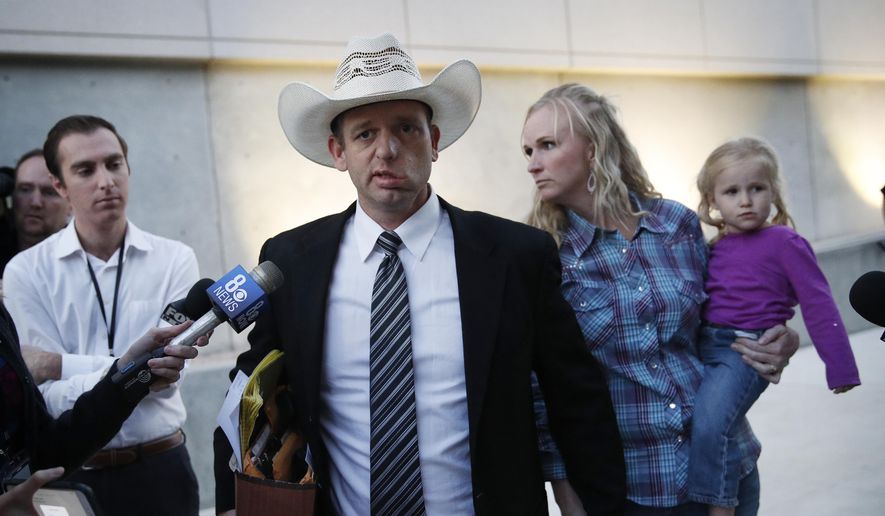 Ryan Bundy, center, walks out of federal court with his wife Angela Bundy, Tuesday, Nov. 14, 2017, in Las Vegas. (AP Photo/John Locher) ** FILE **