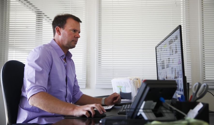In this Wednesday, Nov. 8, 2017, photo, Andrew Stephenson, a marketing director for NewAir, a manufacturing company that makes compact appliances like wine coolers and ice makers, works in his office in Cypress, Calif. When NewAir recruits workers for its busy seasons, the company tells prospective hires they have the chance to keep their jobs when the sales surge is over. While they’re working, they’ll compete for permanent jobs with NewAir’s existing staff. (AP Photo/Jae C. Hong)