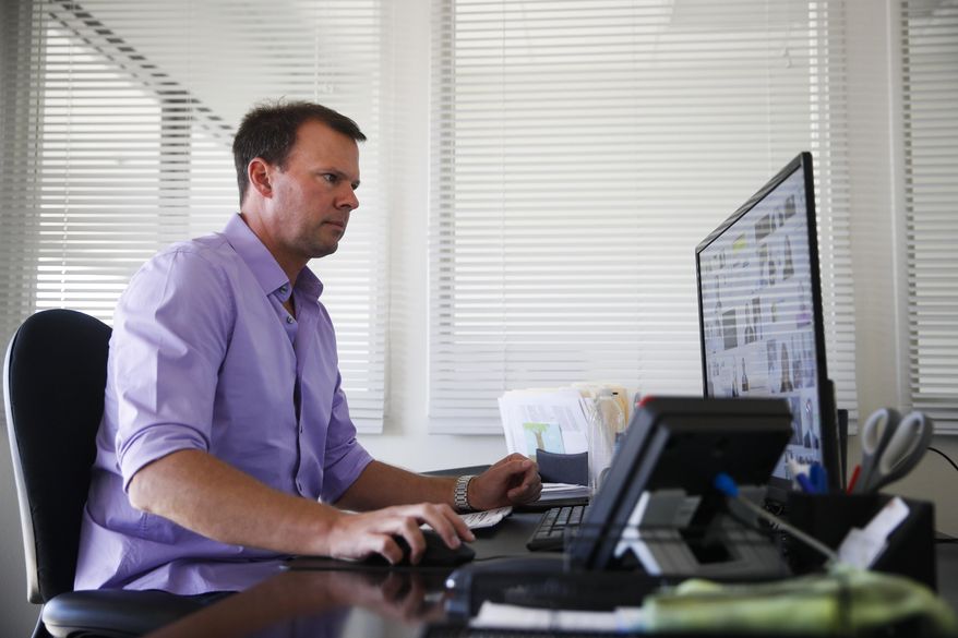 In this Wednesday, Nov. 8, 2017, photo, Andrew Stephenson, a marketing director for NewAir, a manufacturing company that makes compact appliances like wine coolers and ice makers, works in his office in Cypress, Calif. When NewAir recruits workers for its busy seasons, the company tells prospective hires they have the chance to keep their jobs when the sales surge is over. While they’re working, they’ll compete for permanent jobs with NewAir’s existing staff. (AP Photo/Jae C. Hong)