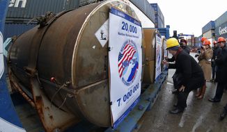 Representatives of participating companies sign containers with uranium to be used as fuel for nuclear reactors, prior to loading them aboard Atlantic Navigator ship,  on a port in St. Petersburg, Russia, Thursday, Nov. 14, 2013. A 20-year program to convert highly enriched uranium from dismantled Russian nuclear weapons into fuel for U.S. power plants has ended, with the final shipment loaded onto a vessel in St. Petersburg&#39;s port on Thursday. The U.S. Energy Department described the program, commonly known as Megatons to Megawatts, as one of the most successful nuclear nonproliferation partnerships ever undertaken. (AP Photo/Dmitry Lovetsky)