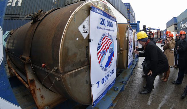 Representatives of participating companies sign containers with uranium to be used as fuel for nuclear reactors, prior to loading them aboard Atlantic Navigator ship,  on a port in St. Petersburg, Russia, Thursday, Nov. 14, 2013. A 20-year program to convert highly enriched uranium from dismantled Russian nuclear weapons into fuel for U.S. power plants has ended, with the final shipment loaded onto a vessel in St. Petersburg&#x27;s port on Thursday. The U.S. Energy Department described the program, commonly known as Megatons to Megawatts, as one of the most successful nuclear nonproliferation partnerships ever undertaken. (AP Photo/Dmitry Lovetsky)