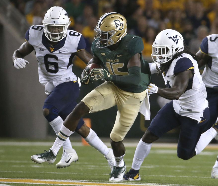 FILE - In this Oct. 21, 2017, file photo, Baylor wide receiver Denzel Mims (15) runs past West Virginia safety Dravon Askew-Henry (6) and cornerback Mike Daniels Jr. (4) during the first half of an NCAA college football game in Waco, Texas. Mims had 152 yards receiving last week, giving him 1,001 for the season. (AP Photo/Jerry Larson, File)