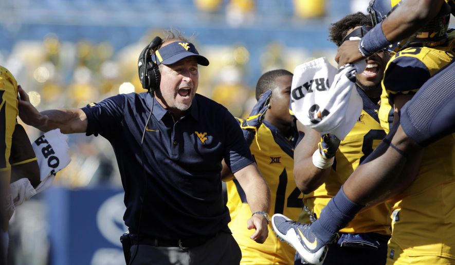 FILE - In this Oct. 14, 2017, file photo, West Virginia coach Dana Holgorsen celebrates a touchdown with his team during the second half of an NCAA college football game against Texas Tech in Morgantown, W.Va. West Virginia faces Texas this week. While the Mountaineers will need help to get into the Big 12 championship game, they first to have to win their own games. Plus, Texas is still trying to get bowl eligible in coach Tom Herman’s first season. (AP Photo/Raymond Thompson, File)