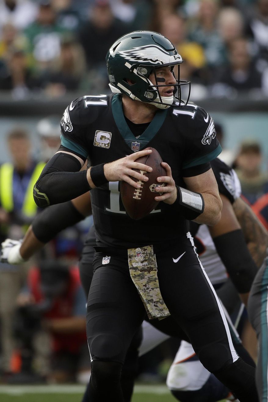 FILE- This Nov. 5, 2017, file photo shows Philadelphia Eagles&#39; Carson Wentz (11) in action during an NFL football game against the Denver Broncos in Philadelphia. Wentz and the Eagles have the best record in the NFL at 8-1 a year after Dak Prescott led the Cowboys on an 11-game winning streak and the best record in the NFC when both quarterbacks were rookies. (AP Photo/Matt Rourke, File)