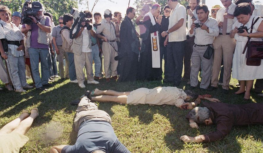 FILE - In this Nov. 16, 1989, file photo, the Archbishop of San Salvador, Mons. Arturo Rivera y Damas and journalists view the bodies of six Jesuit priests murdered in San Salvador. The Roman Catholic Jesuit community in El Salvador said on Thursday, Nov. 16 2017, that it will ask authorities to reopen the case against a group of military officials suspected in the 1989 massacre of six priests and two female employees. (AP Photo/John Hopper, File)