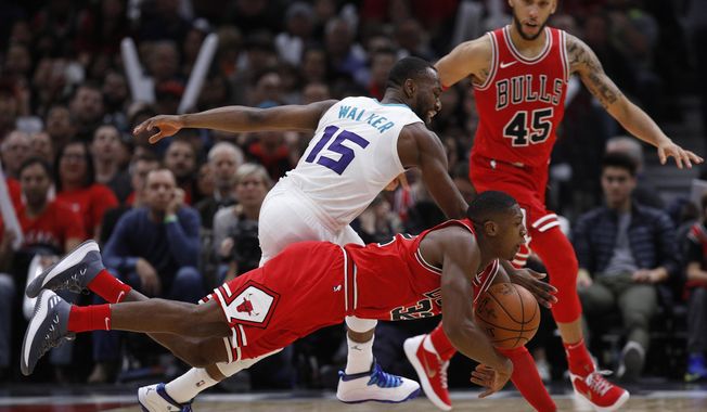 Chicago Bulls&#x27; Kris Dunn dives for the ball against Charlotte Hornets&#x27; Kemba Walker (15) as Bulls&#x27; Denzel Valentine (45) looks on during the second half of an NBA basketball game Friday, Nov. 17, 2017, in Chicago. (AP Photo/Jim Young)