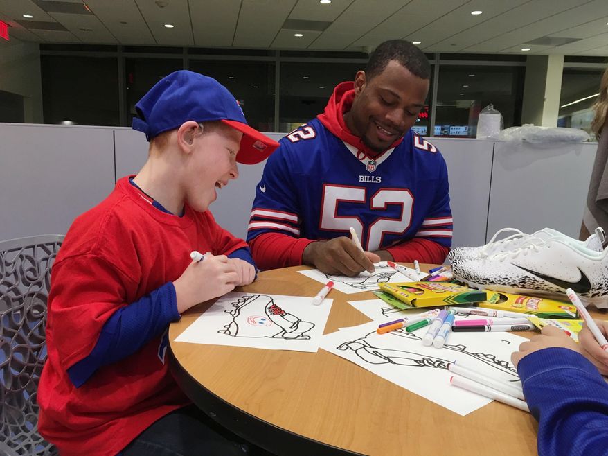 Buffalo Bills linebacker Preston Brown is joined by Will Lucas, left, in helping design customized cleats at Buffalo's John R. Oishei Children's Hospital on Tuesday, Nov. 14, 2017. Brown will be one of three players to wear the customized cleats during Buffalo's home game against the New England Patriots on Dec. 3. The event was held as part of the NFL's "My Cause, My Cleats" campaign in which players are allowed to wear their own style of footwear reflecting their commitment to charitable causes. (Photo by John Wawrow)