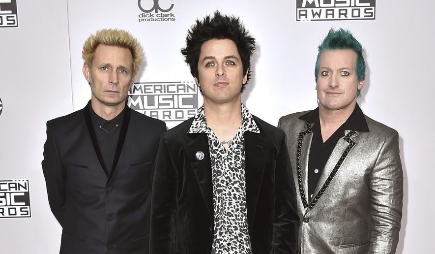 In this Nov. 20, 2016, file photo, Mike Dirnt, from left, Billie Joe Armstrong, and Tre Cool, of Green Day, arrive at the American Music Awards in Los Angeles. The band will release their latest, “Greatest Hits: God's Favorite Band,” on Friday. (Photo by Jordan Strauss/Invision/AP)