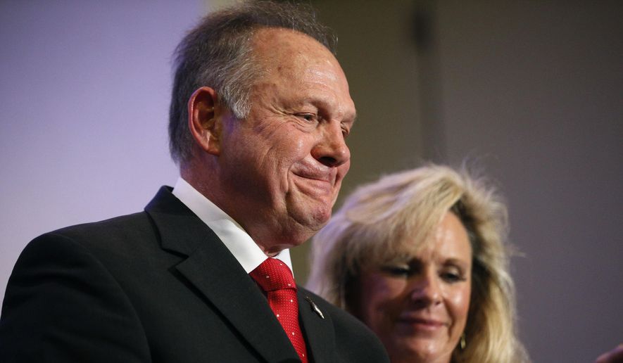 In this Nov. 16, 2017, photo, former Alabama Chief Justice and U.S. Senate candidate Roy Moore speaks at a news conference in Birmingham, Ala., with his wife Kayla Moore, right. (AP Photo/Brynn Anderson)
