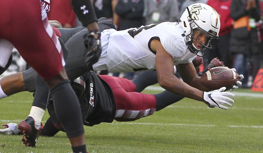 Central Florida's Gabriel Davis reaches for the goal line and scores a touchdown after being hit by Temple's Linwood Crump during the second quarter of an NCAA college football game Saturday, Nov. 18, 2017, in Philadelphia. (AP Photo/Rich Schultz)