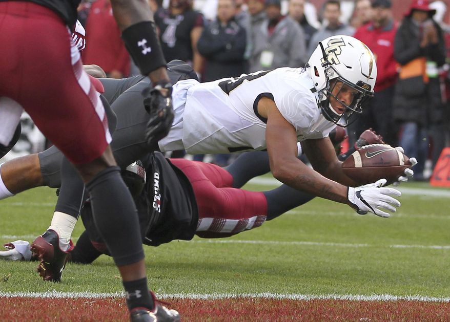 Central Florida's Gabriel Davis reaches for the goal line and scores a touchdown after being hit by Temple's Linwood Crump during the second quarter of an NCAA college football game Saturday, Nov. 18, 2017, in Philadelphia. (AP Photo/Rich Schultz)