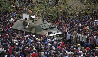 An army armored personnel carrier drives slowly through the gathered crowd of thousands demanding President Robert Mugabe stand down, on the road leading to State House in Harare, Zimbabwe Saturday, Nov. 18, 2017. In a euphoric gathering that just days ago would have drawn a police crackdown, crowds marched through Zimbabwe&#39;s capital on Saturday to demand the departure of President Robert Mugabe, one of Africa&#39;s last remaining liberation leaders, after nearly four decades in power. (AP Photo/Ben Curtis)