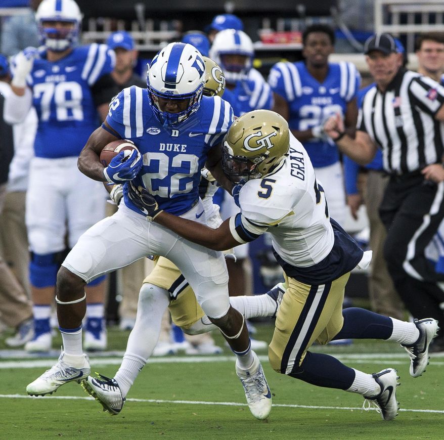 Duke's Brittain Brown (22) carries the ball as Georgia Tech's A.J. Gray (5) attempts a tackle during the first half of an NCAA college football game in Durham, N.C., Saturday, Nov. 18, 2017. (AP Photo/Ben McKeown)