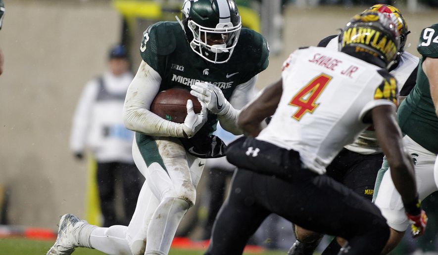 Michigan State's LJ Scott, left, runs for a touchdown against Maryland's Darnell Savage Jr. (4) during the first half of an NCAA college football game, Saturday, Nov. 18, 2017, in East Lansing, Mich. (AP Photo/Al Goldis)