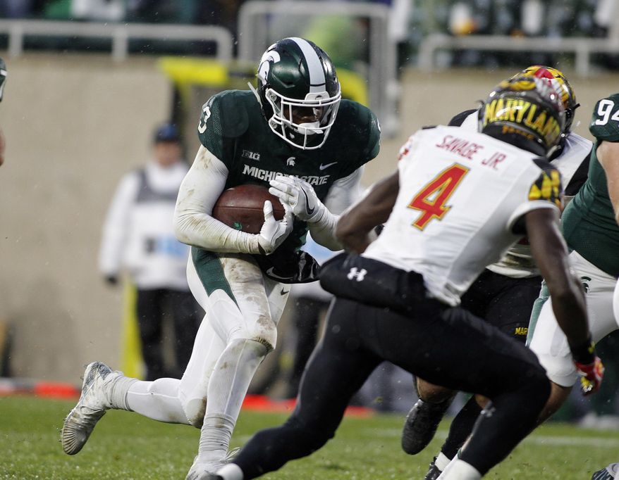 Michigan State's LJ Scott, left, runs for a touchdown against Maryland's Darnell Savage Jr. (4) during the first half of an NCAA college football game, Saturday, Nov. 18, 2017, in East Lansing, Mich. (AP Photo/Al Goldis)