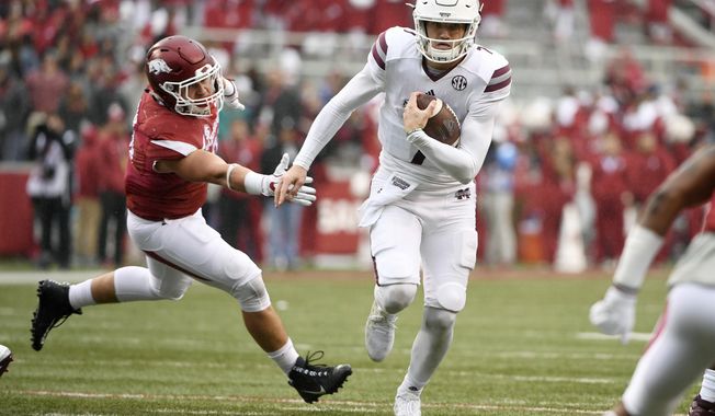 Mississippi State quarterback Nick Fitzgerald slips past Arkansas defender Grant Morgan to score a touchdown during the first half of an NCAA college football game Saturday, Nov. 18, 2017, in Fayetteville, Ark. (AP Photo/Michael Woods)