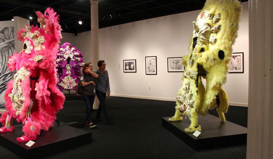 In this Friday, Nov. 17, 2017 photo, Kim Rorschach, director of the Seattle Art Museum, and the museum&#39;s curator of contemporary art, Catharina Manchanda, look at Mardi Gras Indian costumes made by Darryl Montana, on display at the New Orleans Jazz Museum in New Orleans. Prospect.4 opens Sunday and ends Feb. 25. It’s the fourth such exhibit and includes photographs, sculptures, prints, videos and other work, much of it avant-garde, by 73 artists from around the world.  (AP Photo/Janet McConnaughey)
