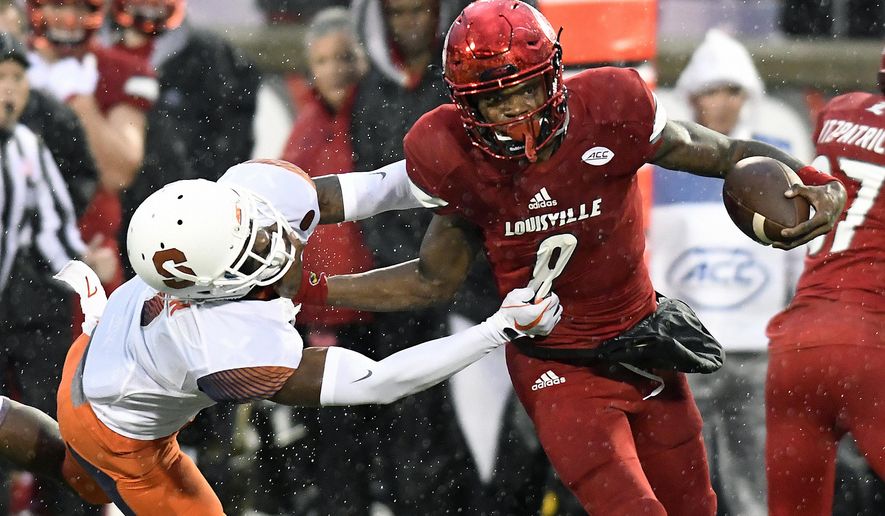 Louisville quarterback Lamar Jackson (8) runs from the grasp of Syracuse defensive back Devin M. Butler (7) during the first half of an NCAA college football game, Saturday, Nov. 18, 2017, in Louisville, Ky. (AP Photo/Timothy D. Easley)
