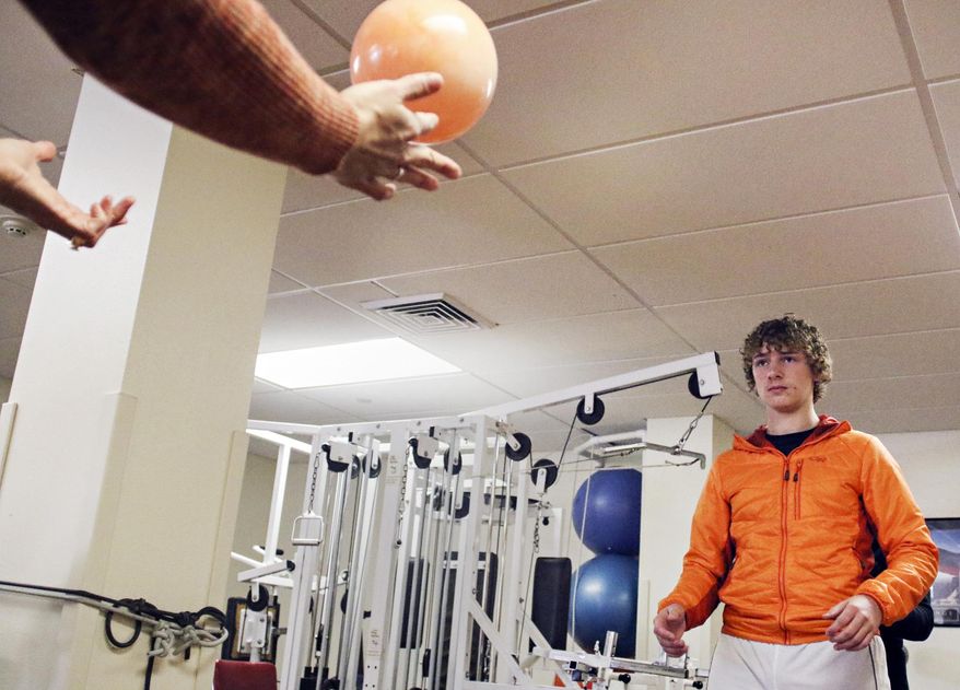 In this Nov. 9, 2017 photo, Nick Daugherty plays catch with a ball during a physical therapy session at the St. Luke Community Clinic in Ronan, Mont. Daugherty's life changed after suffering concussion. (Greg Lindstrom/Flathead Beacon via AP)