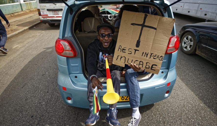 Protesters demanding President Robert Mugabe stand down ride in the back of a car with a placard &amp;quot;Rest in peace Mugabe&amp;quot; as they drive towards State House in Harare, Zimbabwe Saturday, Nov. 18, 2017. In a euphoric gathering that just days ago would have drawn a police crackdown, crowds marched through Zimbabwe&#39;s capital on Saturday to demand the departure of President Robert Mugabe, one of Africa&#39;s last remaining liberation leaders, after nearly four decades in power. (AP Photo/Ben Curtis)