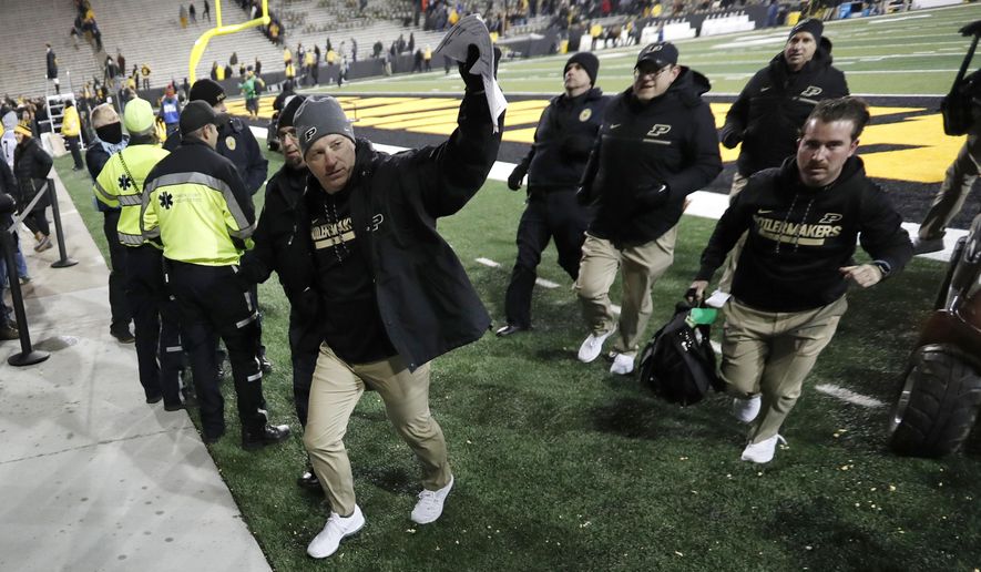 Purdue head coach Jeff Brohm, left, waves to fans as he runs off the field after an NCAA college football game against Iowa, Saturday, Nov. 18, 2017, in Iowa City, Iowa. Purdue won 24-15. (AP Photo/Charlie Neibergall)