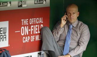 FILE-This Sept. 4, 2015, file photo shows Atlanta Braves assistant general manager and director of pro scouting John Coppolella talking on the phone in the dugout during batting practice before a baseball game against the Washington Nationals at Nationals Park, in Washington. Baseball Commissioner Rob Manfred has hit the Atlanta Braves with heavy sanctions, including the loss of nine players, for rules violations committed by the team in the international player market. Manfred on Tuesday, Nov. 21, 2017,  also placed former Braves general manager Coppolella on the permanently ineligible list. Former Braves Special Assistant Gordon Blakeley, the team&#39;s international scouting chief, is suspended from performing services for any team for one year. (AP Photo/Alex Brandon, File) **FILE**