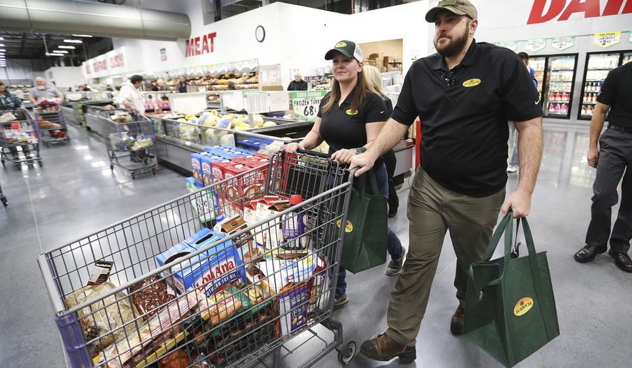 In this Friday, Nov. 17, 2017 photo, retired U.S. Army Cpl. Nicholas Mannino and his wife, Stephanie, shop at the WinCo grocery store in South Salt Lake. Authorities say the Layton couple won $10,400 worth of groceries at the WinCo store-opening on Friday, face felony charges alleging the theft of more than $5,000 worth of merchandise from another store.(Jeffrey D. Allred/The Deseret News via AP)