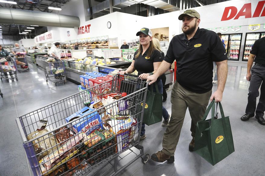 In this Friday, Nov. 17, 2017 photo, retired U.S. Army Cpl. Nicholas Mannino and his wife, Stephanie, shop at the WinCo grocery store in South Salt Lake. Authorities say the Layton couple won $10,400 worth of groceries at the WinCo store-opening on Friday, face felony charges alleging the theft of more than $5,000 worth of merchandise from another store.(Jeffrey D. Allred/The Deseret News via AP)