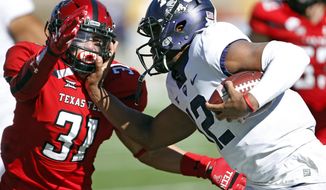 FILE - In this Saturday, Nov. 18, 2017, file photo, TCU&#39;s Shawn Robinson (12) tries to run around Texas Tech&#39;s Justus Parker (31) during the second half of an NCAA college football game in Lubbock, Texas. quarterback to step up as the regular season winds down. For the Horned Frogs, Shawn Robinson became the first true freshman quarterback to start for coach Gary Patterson in his 17 seasons as the head coach in last week’s 27-3 win over Texas Tech. (AP Photo/Brad Tollefson, File)