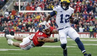 FILE - In this Nov. 18, 2017, file photo, Michigan&#39;s Chris Evans (12) runs past Wisconsin&#39;s T.J. Edwards, left, during the first half of an NCAA college football game in Madison, Wis. The unranked Wolverines need Evans to make all the right moves on the field at the Big House against No. 8 Ohio State. To pull off a big upset and spoil the Buckeyes&#39; chances of playing for a national championship, Michigan might need Evans to have the kind of day Tshimanga Biakabutuka had in 1995 when he ran for 313 yards in one of the finest performances in the rivalry. (AP Photo/Morry Gash, File)