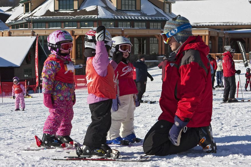 This undated photo provided by Stowe Mountain Resort in Stowe, Vt., shows an instructor with young children in a ski lesson. Kids differ in their readiness and learning styles when it comes to learning to ski, but experts say the most important thing for parents to consider is making the experience fun. (Dave Schmidt/Stowe Mountain Resort via AP)