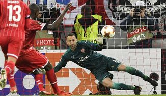 Cologne&#x27;s Sehrou Guirassy scores the opening goal from the penalty spot past Arsenal goalkeeper David Ospina, right, during the soccer Europa League group H match between FC Cologne and Arsenal in Cologne, Germany, Thursday, Nov. 23, 2017. (AP Photo/Martin Meissner)