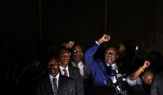 Zimbabwe&#39;s President in waiting Emmerson Mnangagwa, center-right, speaks to supporters gathered outside the Zanu-PF party headquarters in Harare, Zimbabwe Wednesday, Nov. 22, 2017. Mnangagwa has emerged from hiding and returned home ahead of his swearing-in Friday. Crowds have gathered at the ruling party&#39;s headquarters for his first public remarks. Mnangagwa will replace Robert Mugabe, who resigned after 37 years in power when the military and ruling party turned on him for firing Mnangagwa and positioning his wife to take power. (AP Photo/Ben Curtis)