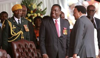 Emmerson Mnangagwa, centre, takes his seat at his presidential inauguration ceremony in Harare, Zimbabwe, Friday, Nov. 24, 2017. Mnangagwa is being sworn in as Zimbabwe&#39;s president after Robert Mugabe resigned on Tuesday, ending his 37 year rule. (AP Photo/Tsvangirayi Mukwazhi)