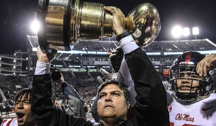 Mississippi interim coach Matt Luke holds the Golden Egg trophy following the team&#39;s 31-28 win over Mississippi State in an NCAA college football game in Starkville, Miss., Thursday, Nov. 23, 2017. (Bruce Newman/The Oxford Eagle via AP)