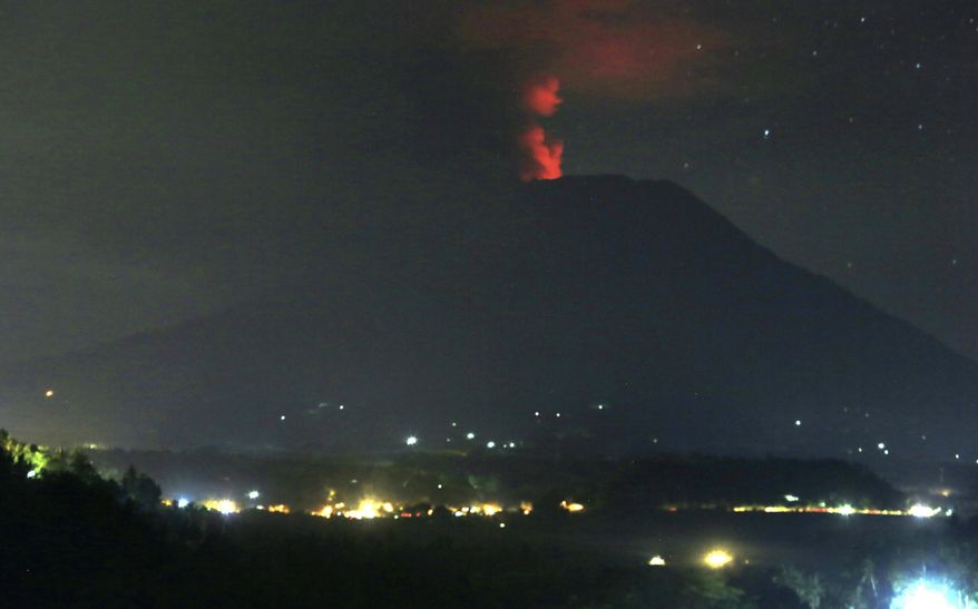 A view of the Mount Agung volcano erupting, in Karangasem, Bali island, Indonesia, early Sunday, Nov. 26, 2017. A volcano on the Indonesian tourist island of Bali erupted for the second time in a week on Saturday, disrupting international flights even as authorities said the island remains safe. (AP Photo/Firdia Lisnawati)