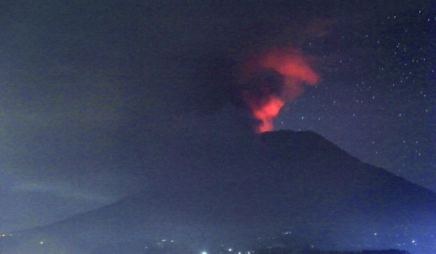 A view of the Mount Agung volcano erupting, in Karangasem, Bali island, Indonesia, early Sunday, Nov. 26, 2017. A volcano on the Indonesian tourist island of Bali erupted for the second time in a week on Saturday, disrupting international flights even as authorities said the island remains safe. (AP Photo/Firdia Lisnawati)