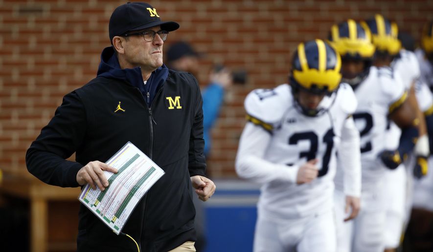 FILE - In this Nov. 11, 2017, file photo, Michigan coach Jim Harbaugh runs onto the field with his team before an NCAA college football game against Maryland in College Park, Md. Harbaugh is winless against Ohio State in the three rivalry games since he became coach. (AP Photo/Patrick Semansky, File)