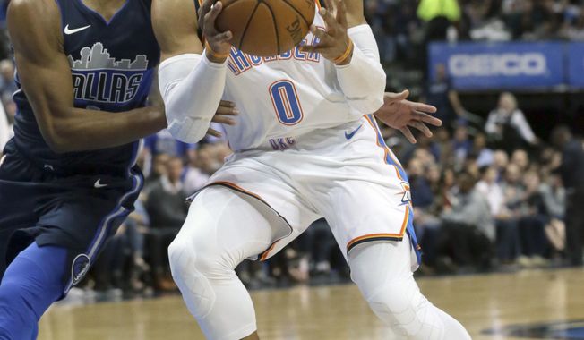 Oklahoma City Thunder guard Russell Westbrook (0) passes off the ball against Dallas Mavericks guard Dennis Smith Jr. during the first half of an NBA basketball game in Dallas, Saturday, Nov. 25, 2017. (AP Photo/LM Otero)