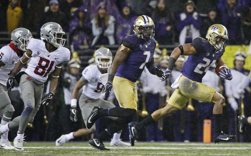 Washington defensive back Ezekiel Turner, right, runs with the ball after he intercepted a Washington State pass during the first half of an NCAA college football game, Saturday, Nov. 25, 2017, in Seattle. (AP Photo/Ted S. Warren)