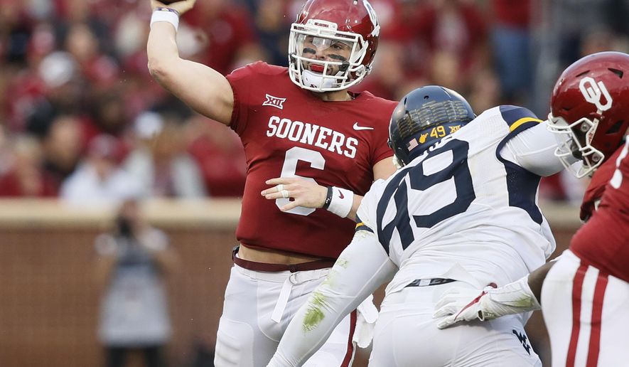 Oklahoma quarterback Baker Mayfield (6) passes under pressure from West Virginia West Virginia defensive lineman Lamonte McDougle (49) in the second quarter of an NCAA college football game in Norman, Okla., Saturday, Nov. 25, 2017. (AP Photo/Sue Ogrocki)