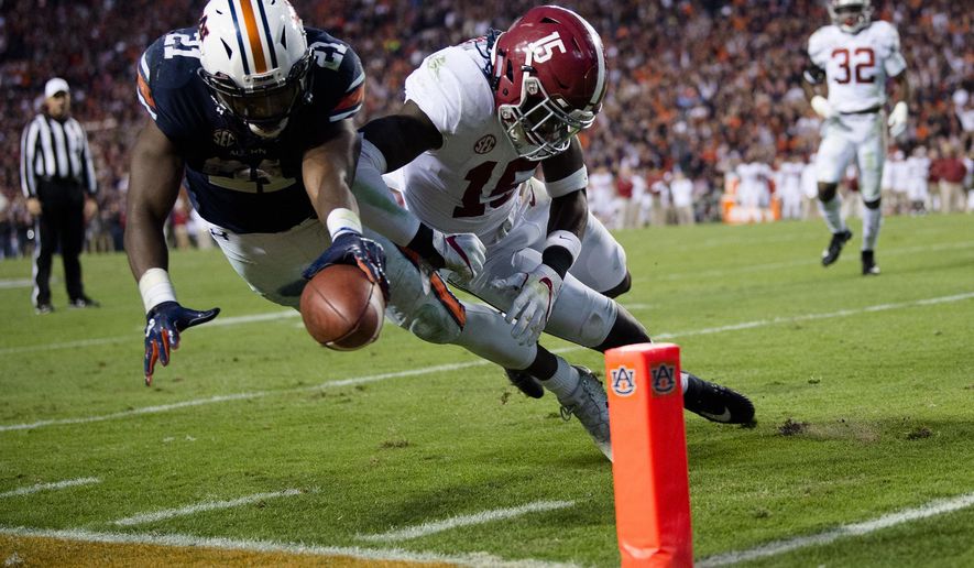 Auburn running back Kerryon Johnson (21) dives for the end zone and gets a first down as Alabama defensive back Ronnie Harrison (15) knocks him out of bounds during the Iron Bowl NCAA football game Saturday, Nov. 25, 2017, in Auburn, Ala. (Albert Cesare/The Montgomery Advertiser via AP)