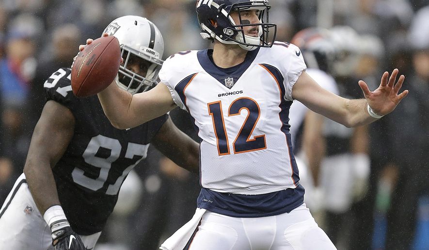 Denver Broncos quarterback Paxton Lynch (12) passes in front of Oakland Raiders defensive end Mario Edwards Jr. (97) during the first half of an NFL football game in Oakland, Calif., Sunday, Nov. 26, 2017. (AP Photo/Ben Margot)