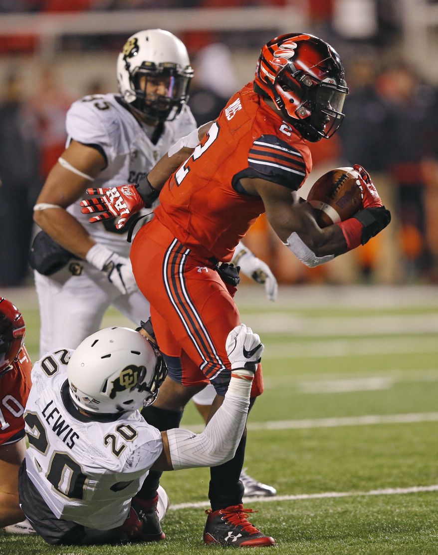 Utah running back Zack Moss (2) drags Colorado linebacker Drew Lewis (20) during the first half of an NCAA college football game Saturday, Nov. 25, 2017, in Salt Lake City. (AP Photo/Rick Bowmer)