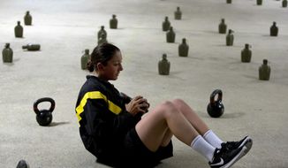 A female U.S. Army recruit exercise before dawn at Ft. Benning, Ga., on Oct. 4, 2017. The Army’s introduction of women into the infantry has moved steadily but cautiously this year. As home to the previously all-male infantry and armor schools, Fort Benning had to make a number of adjustments, including female dorm rooms, security cameras, monitoring stations. (AP Photo/John Bazemore)