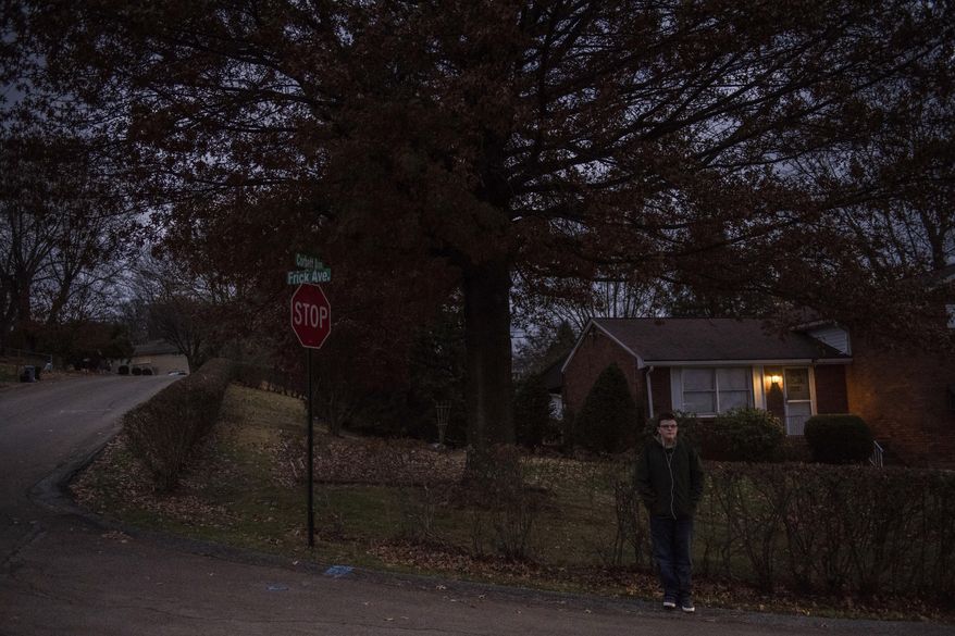 In this Friday, Nov. 17, 2017, photo, Seth Weston, a ninth grader at Hempfield Area High School, waits for the bus at Frick and Corbett Avenues in Hempfield Township, Pa. School districts in and around Pittsburgh, including some whose first bell rings at 7 a.m., are evaluating daily schedules as research and day-to-day experience make it increasingly clear that later start times could benefit students' mental health and academic success. (Dan Speicher/Pittsburgh Tribune-Review via AP)