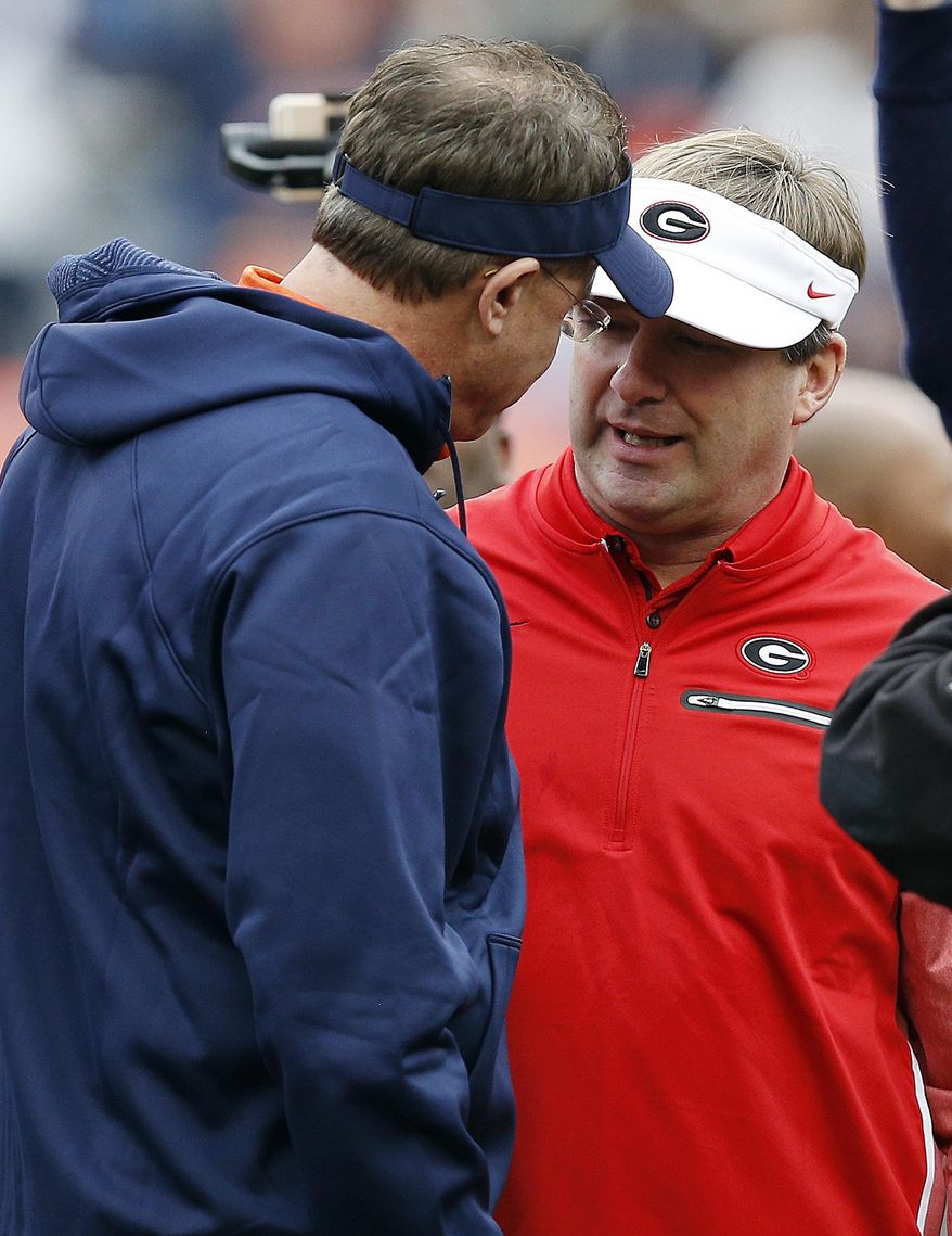 FILE - In this Nov. 11, 2017, file photo, Auburn head coach Gus Malzahn, left, and Georgia head coach Kirby Smart, right, meet before an NCAA college football game in Auburn, Ala. No. 6 Georgia is getting ready for a rematch with No. 4 Auburn in the SEC championship game. (AP Photo/Brynn Anderson, File)