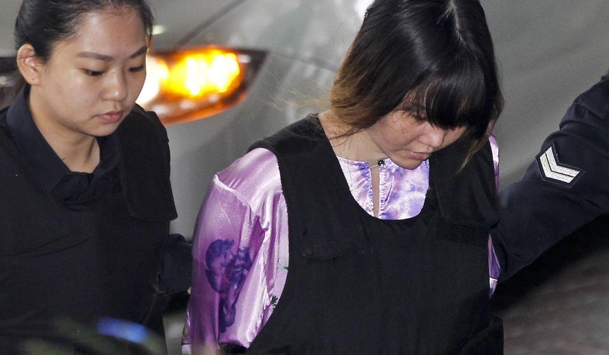 Vietnamese Doan Thi Huong, right, is escorted by police as she arrives for a court hearing at the Shah Alam court house in Shah Alam, outside Kuala Lumpur, Malaysia, Monday, Nov. 27, 2017. Huong and Indonesia Siti Aisyah are accused of killing Kim Jong Nam, the estranged half brother of North Korean leader Kim Jong Un. (AP Photo/Sadiq Asyraf)